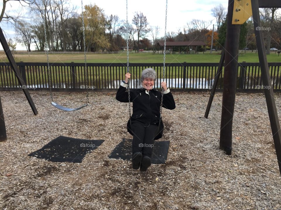 Woman swinging on a swing in park