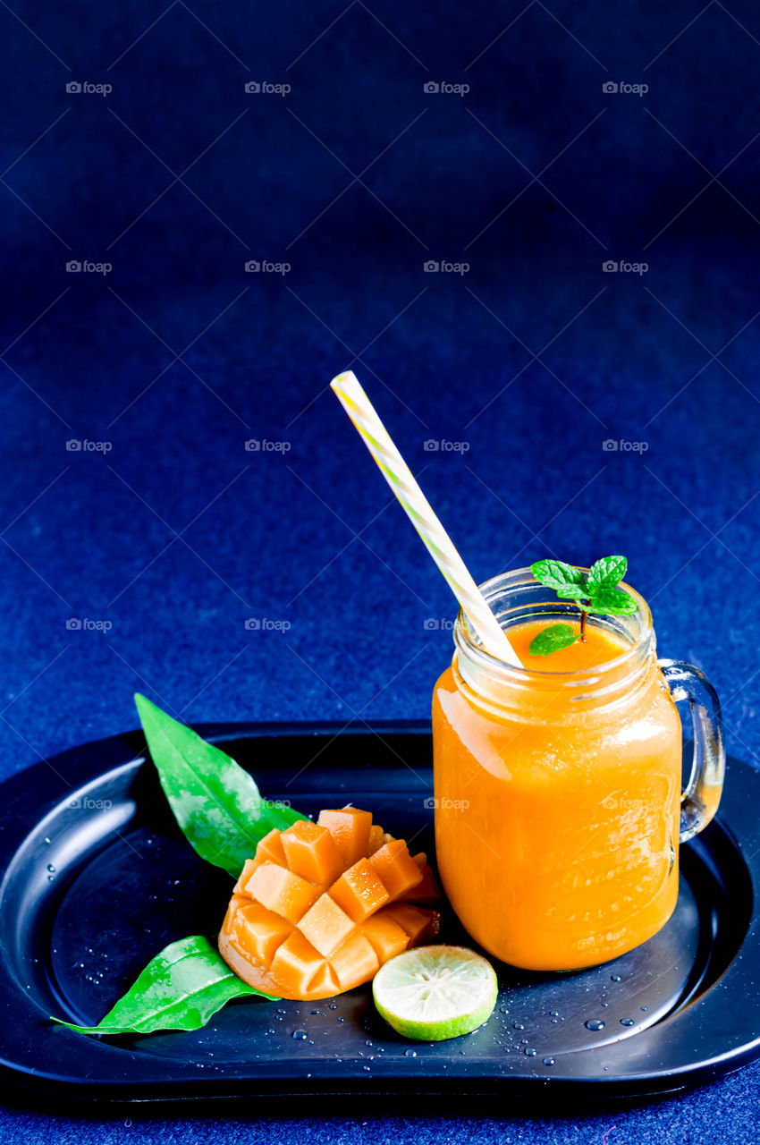 Mango drink isolated on blue background.Orange x blue.