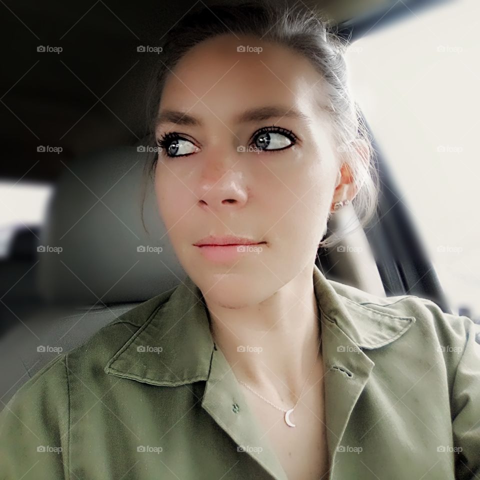 woman sitting in car looking off to the side