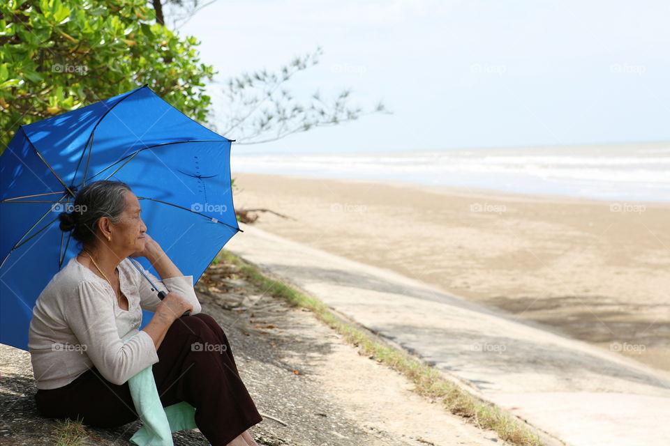 Serenity. My dear grandmother watching and taking care of the children playing at the beach in Miri, Malaysia