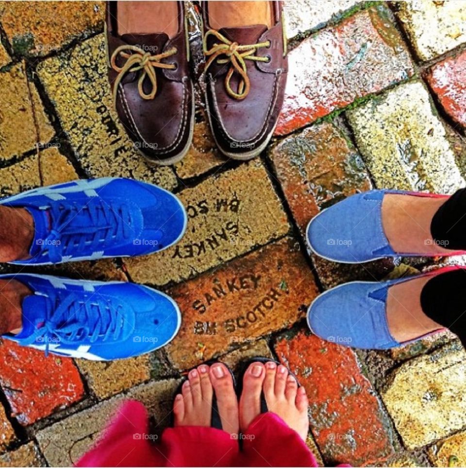 Four friends with four different footwears. Boat shoes, loafers, sandals and sneakers.
