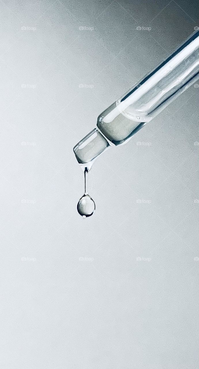 Drop of oil from a pipette in black and white