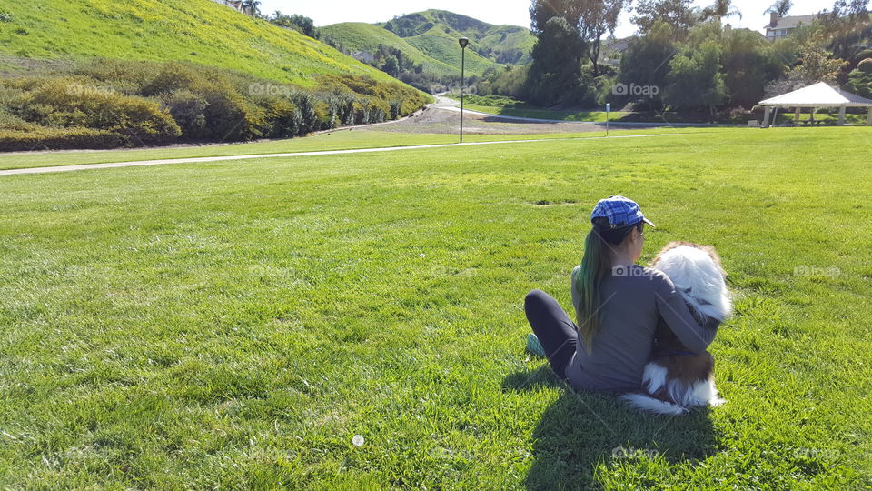 Dog and woman looking at the view, sitting side by side at the park, man's bestfriend