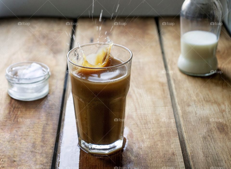 Iced coffee in a glass on a wooden table.