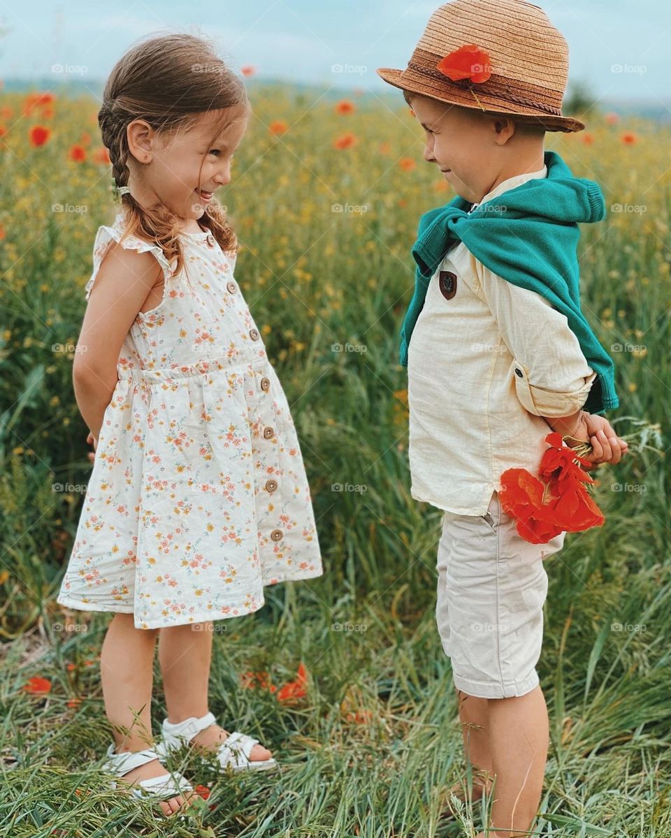 A boy and the little girl in the field of flowers