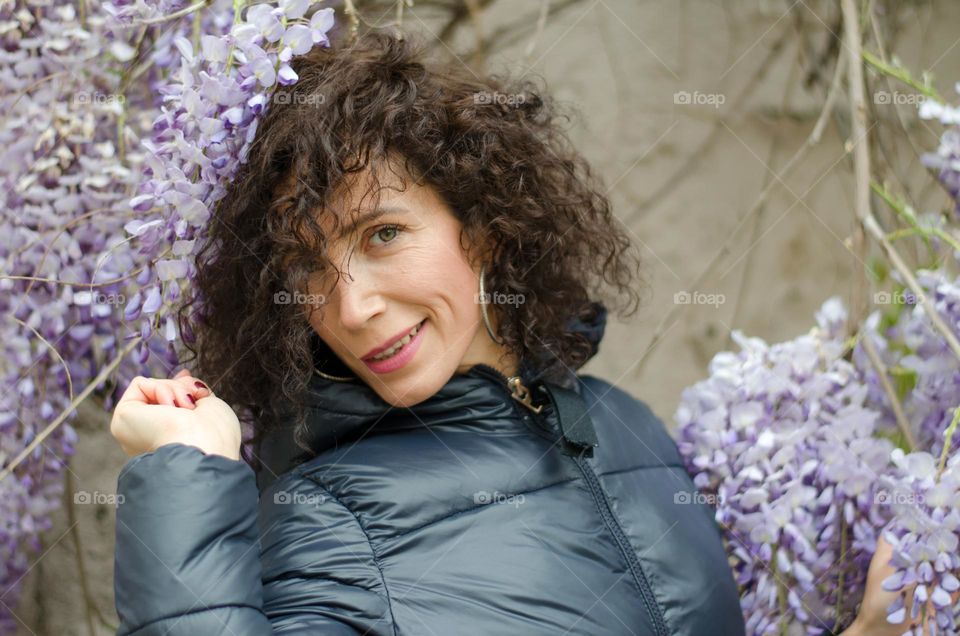 Portrait of a woman brunette on background of Wisteria