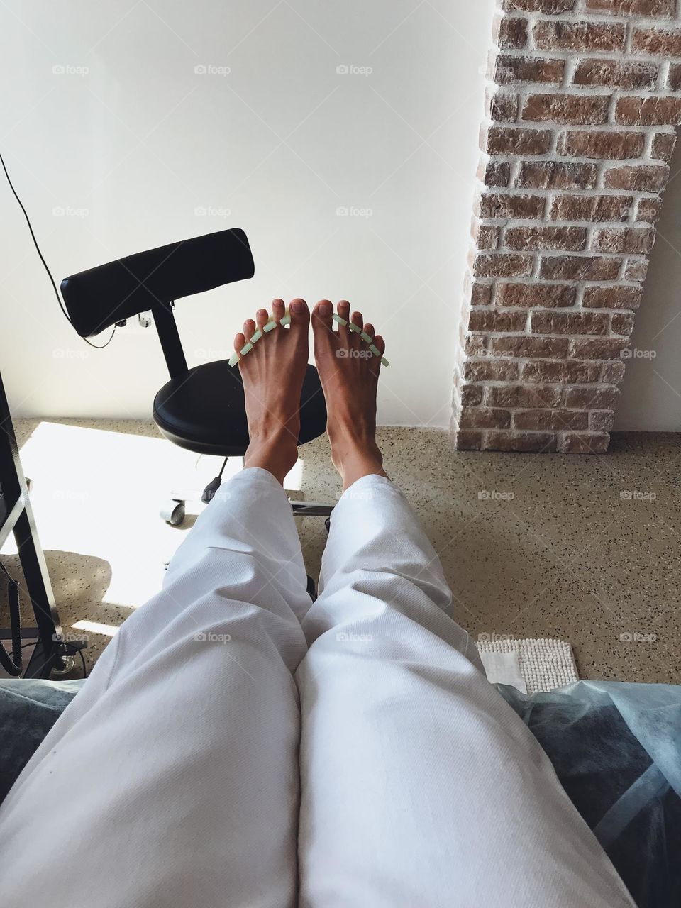 Anonymous female feet on pedicure in beauty salon 