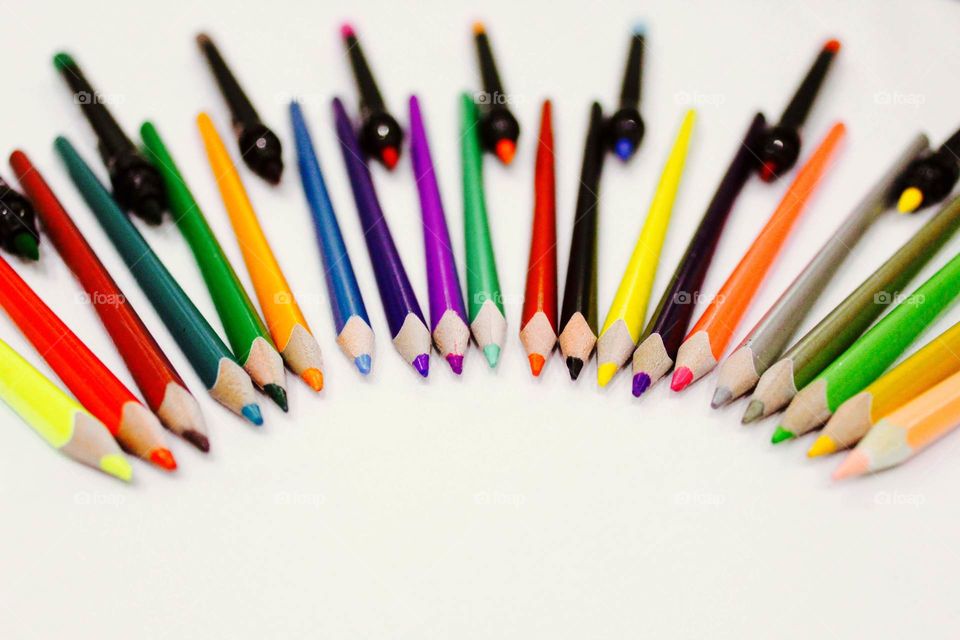 Pencils and colored pens lined up on the table