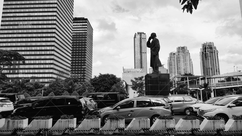 Hero statue between multi-storey buildings