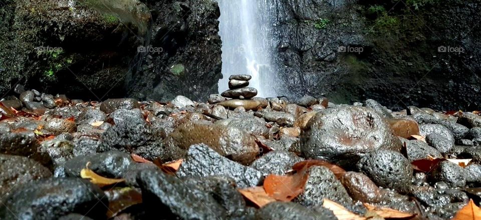 rock balancing in front of the waterfall