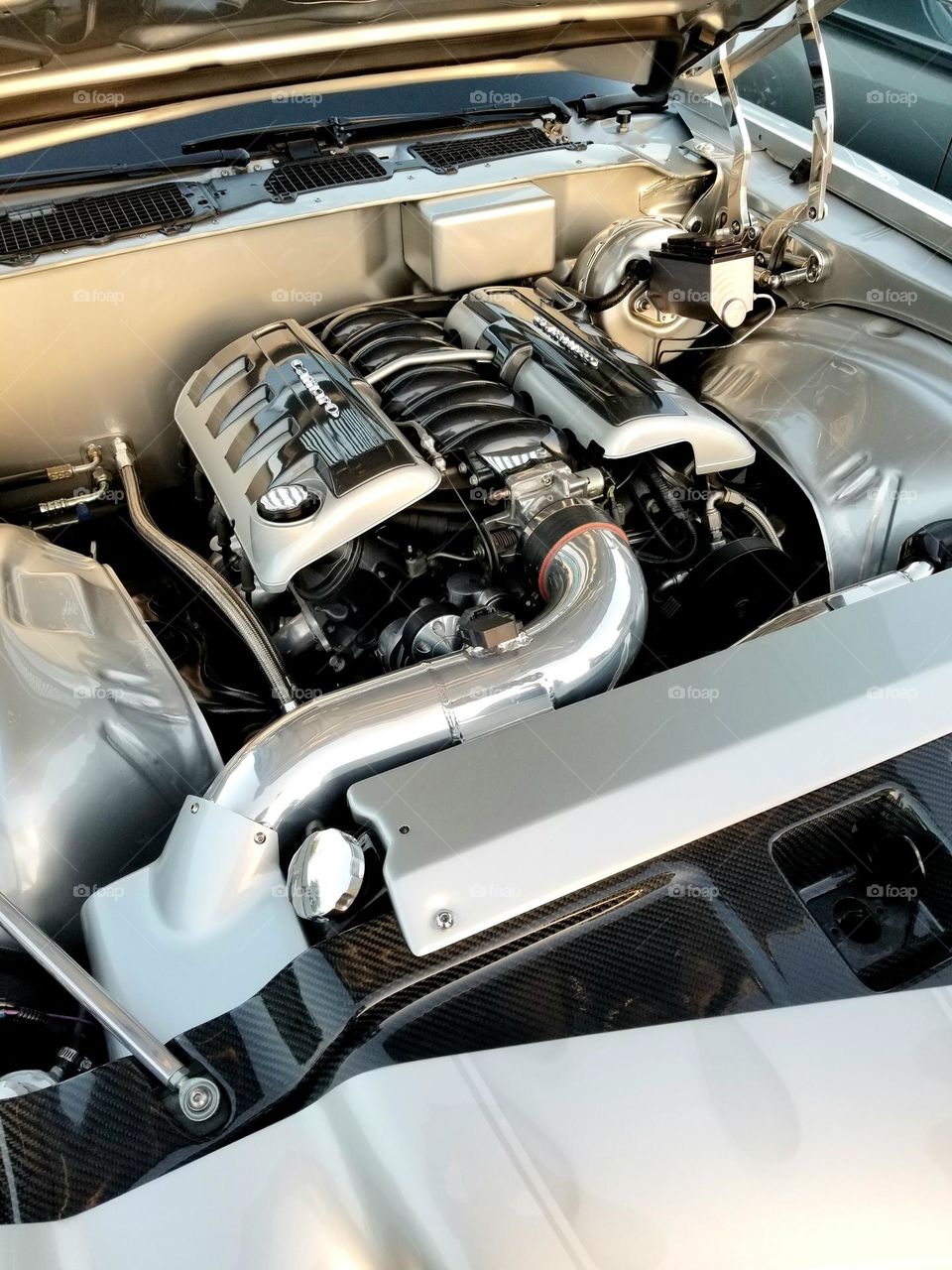 A modern LS motor lies in a 1972 Chevy Camaro restomod at a car show