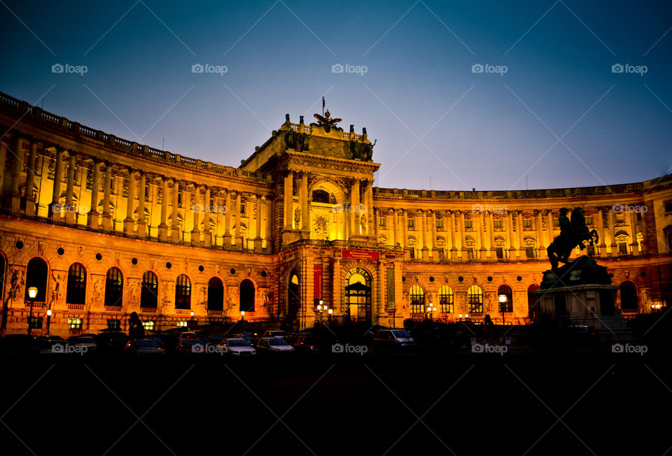 Old and New. cars against the lit backdrop of Hofburg Palace. Vienna, Austria.