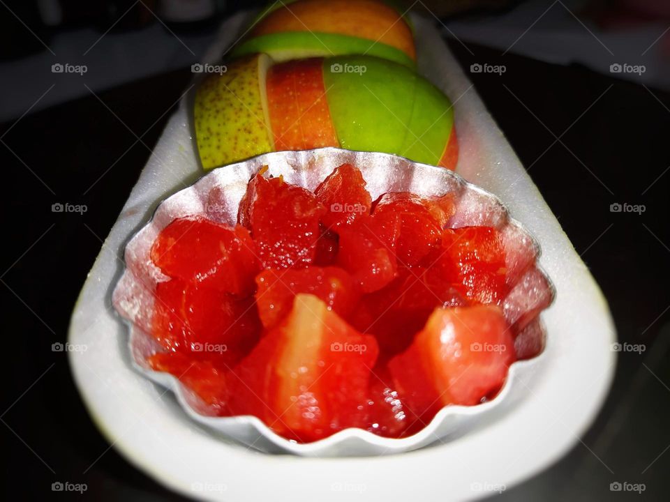 Beautiful vibrant water melon slices and apple slices on a bowl close shot.