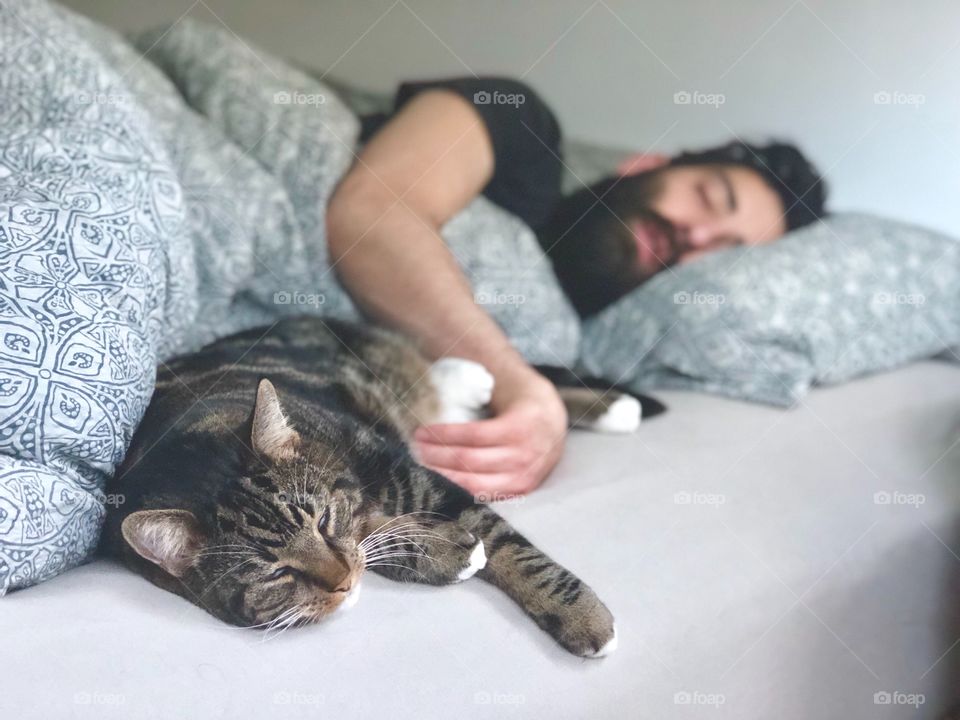 A man and a cat sleeping 