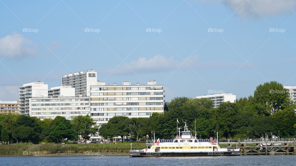 Buildings and ferry on the riverside in Antwerp, Belgium.