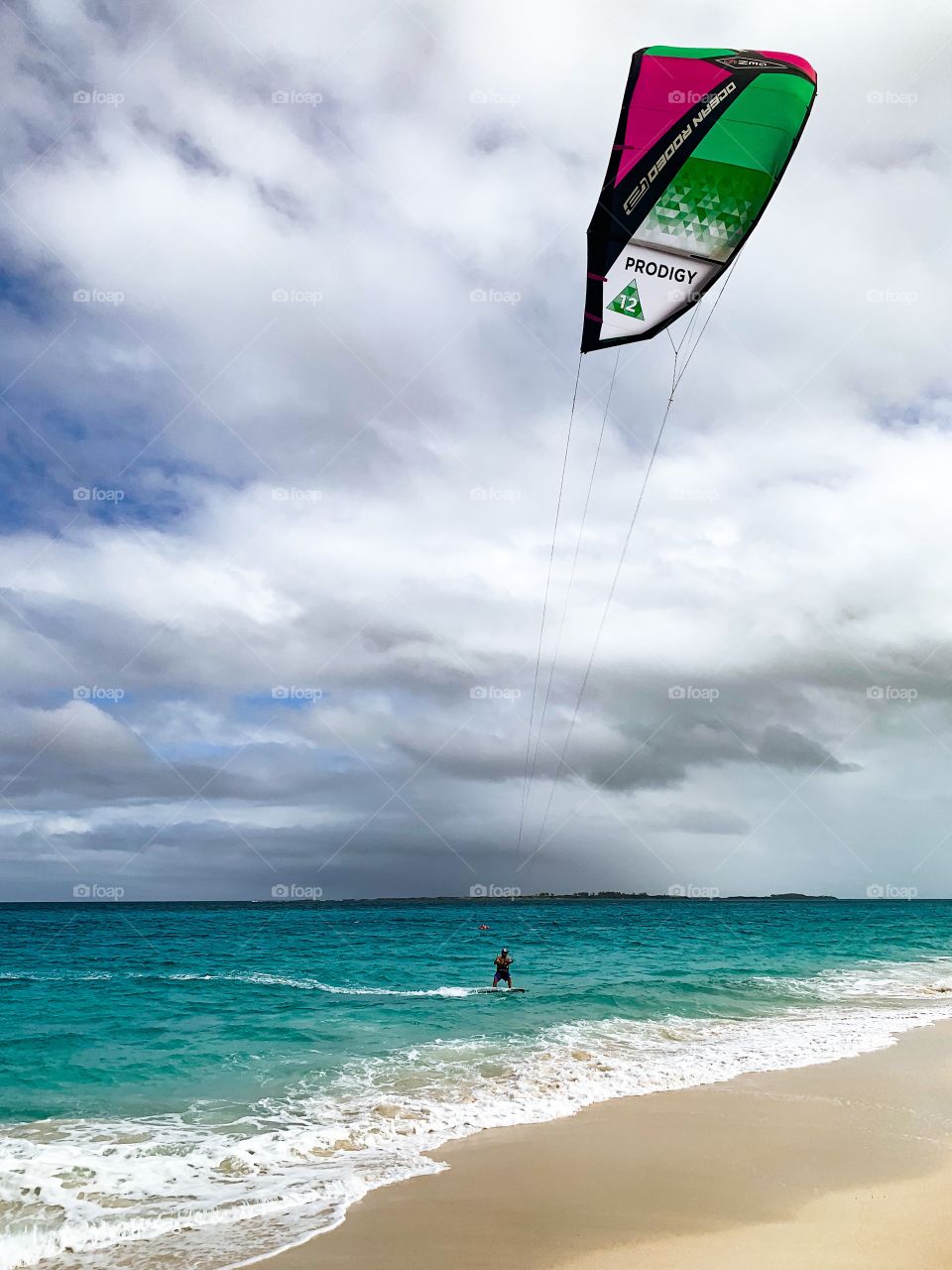 Person in the water on the beach with a parasail