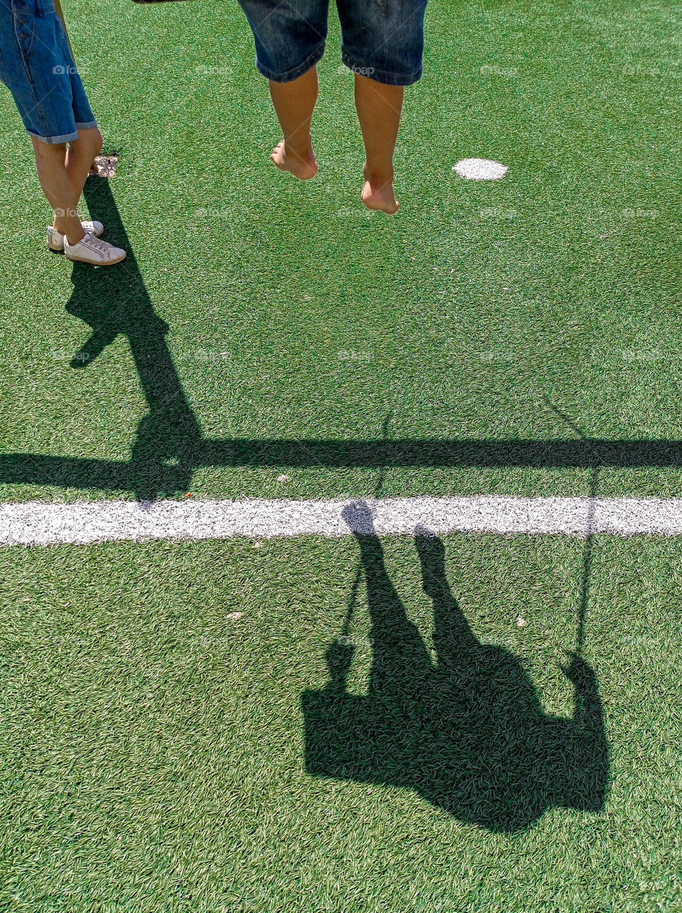 the shadow of a little boy on a swing