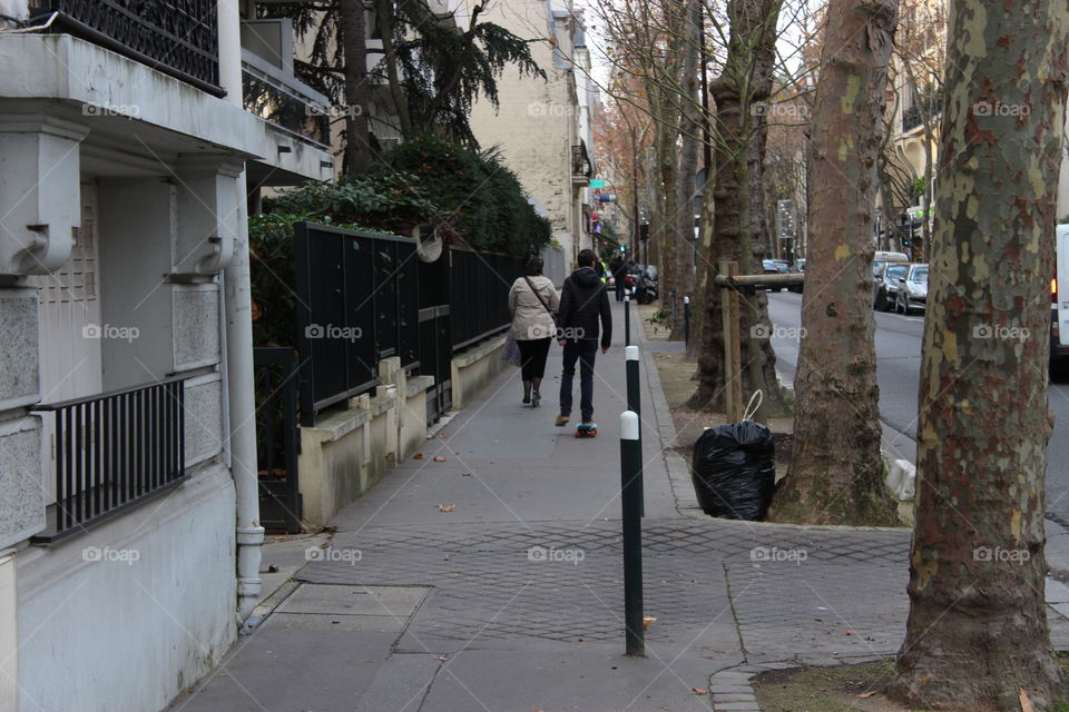 Boy and mother move with skateboarding on the sidewalk,Paris,France