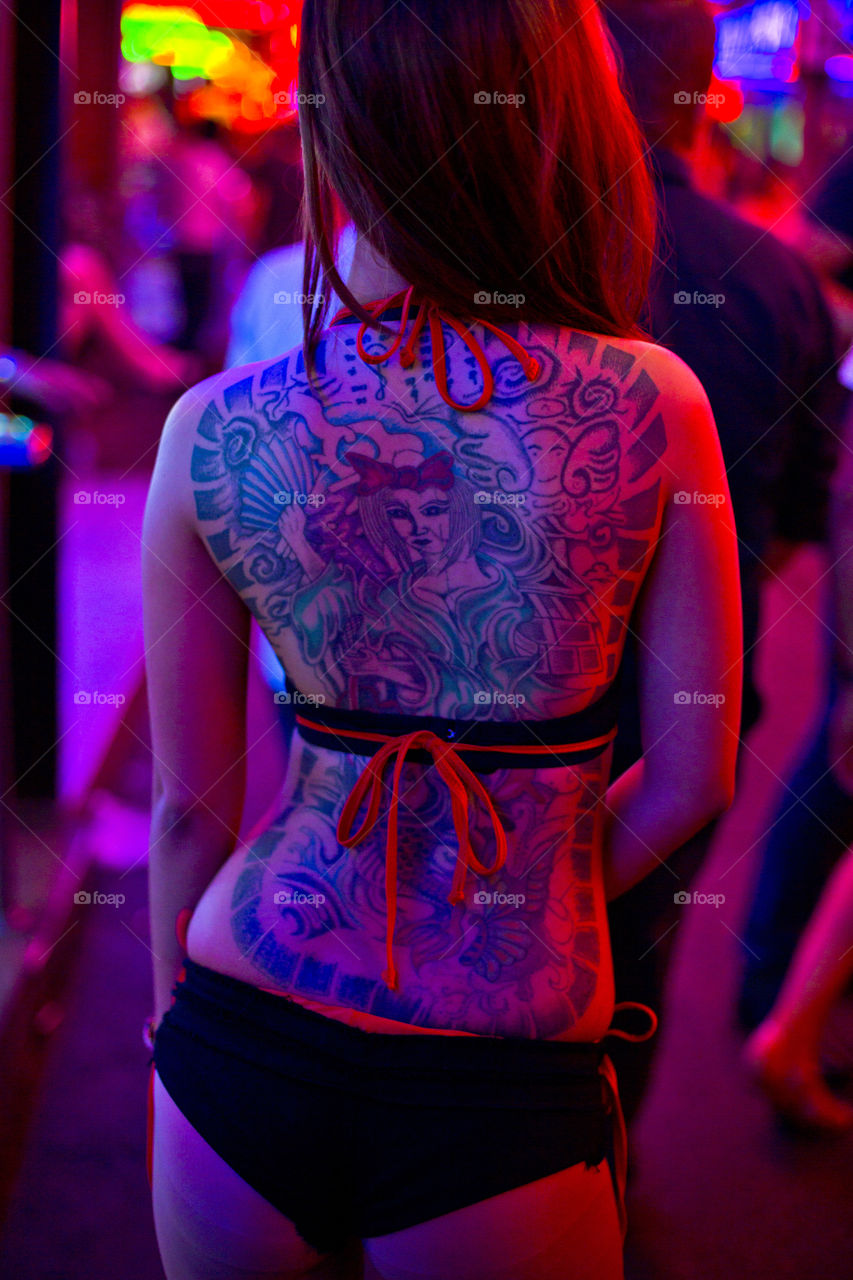 Colors of the night. back portrait of a tattooed night girl street worker