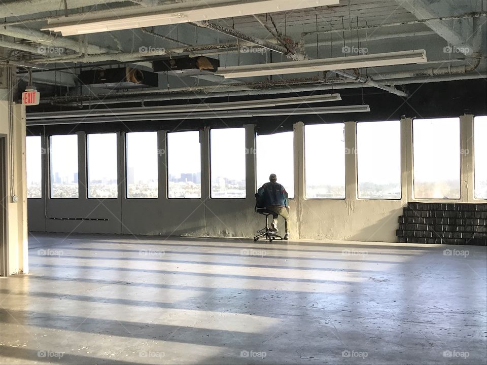 Industrial warehouse empty studio with man looking out window 