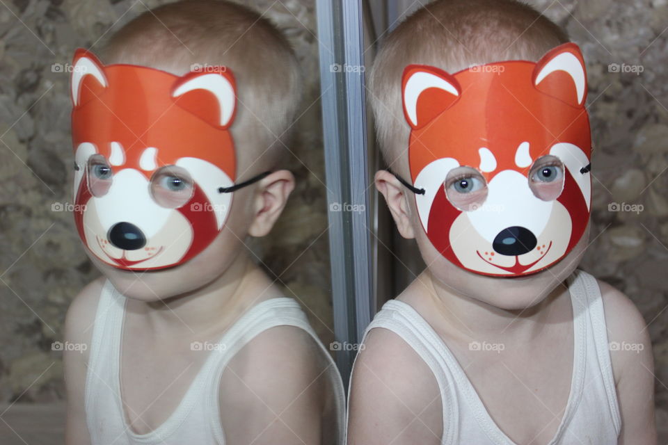 boy in funny mask reflection in the mirror