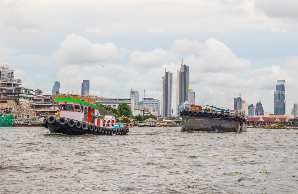 a Tug or Tow Boat with a freight ship at the Chao Phraya River of the Capital City Bangkok Thailand Southeast Asia