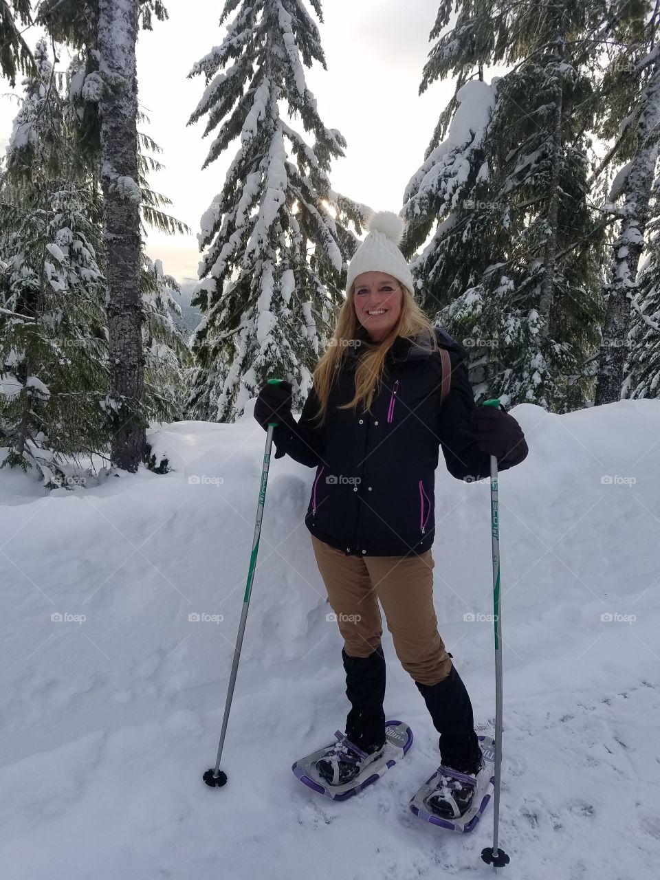 Smiling woman with ski in the winter landscape