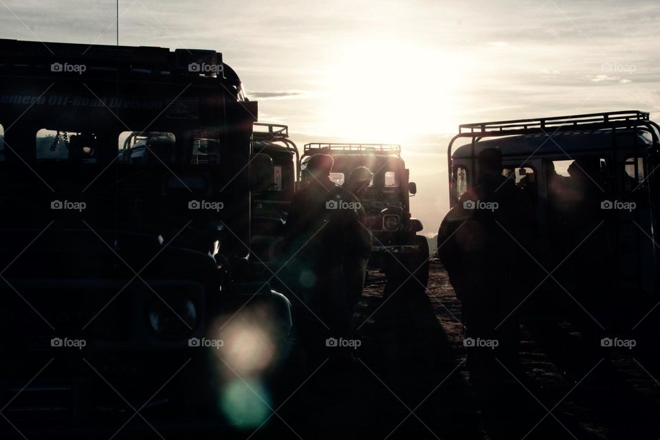 Sunrise that illuminates the Jeep Parking in a parking area on a hill in the Bromo mountains, East Java.