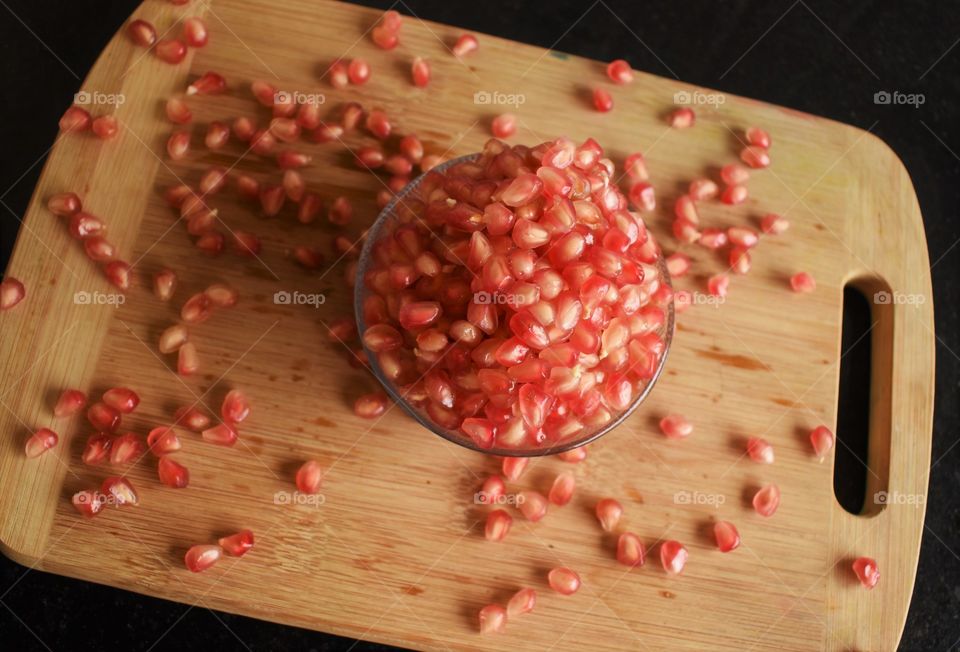 pomegranate seeds on cutting board