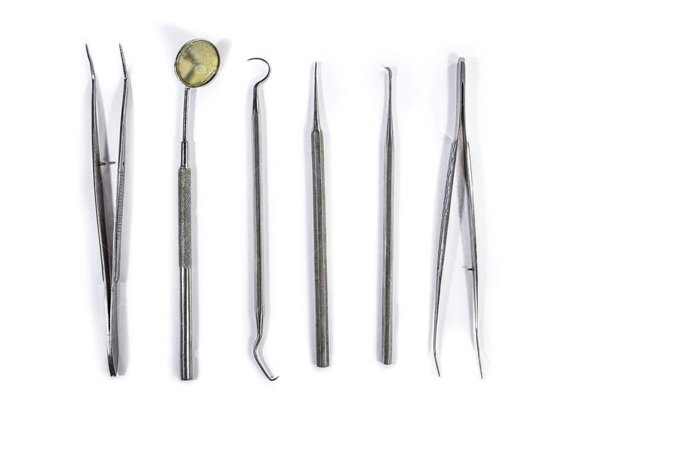 Medical Dental instruments mirror etc on the white background isolated and arranged on white background in the table.