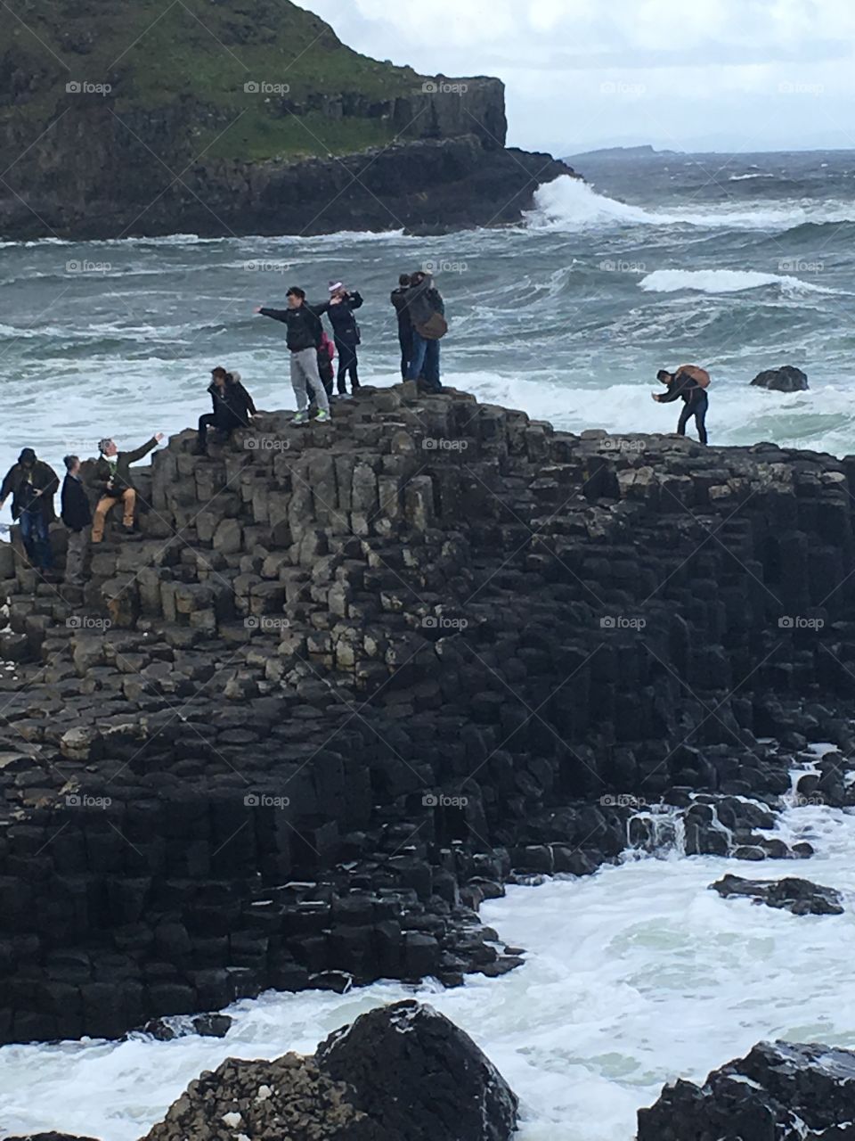 A far-away view of tourists taking pictures at Giant’s Causeway in Northern Ireland 