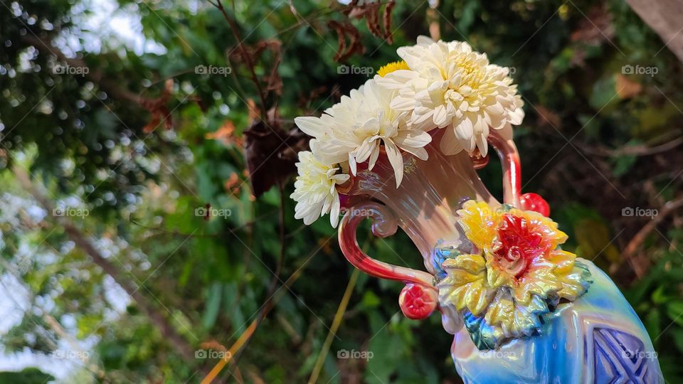 Beautiful white flowers in a colourful flowerpot with a flower sculpture, Flowers in a vase, colourful vase, white flowers in a vase