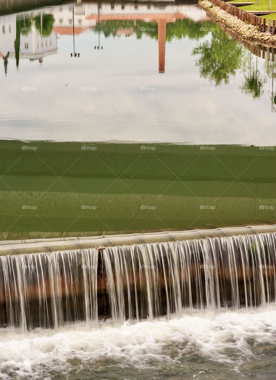 Tomar reflected in the Rio Nabão running into a man-made weir.