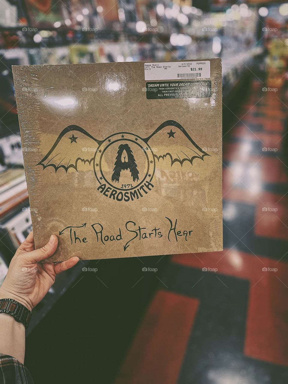 Woman shopping for vinyls in a record shop, supporting a local record shop, woman finds rock and roll album, Aerosmith vinyl record, Aerosmith The Road Starts Hear, Aerosmith music, rocking out to Aerosmith, good rock and roll music, Aerosmith vinyl