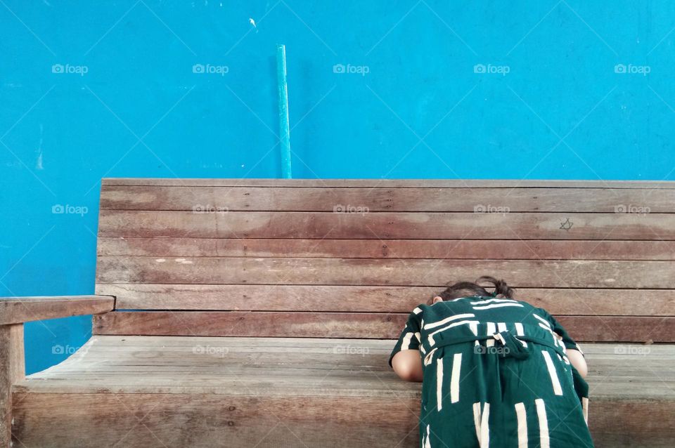 little girl playing on wooden bench