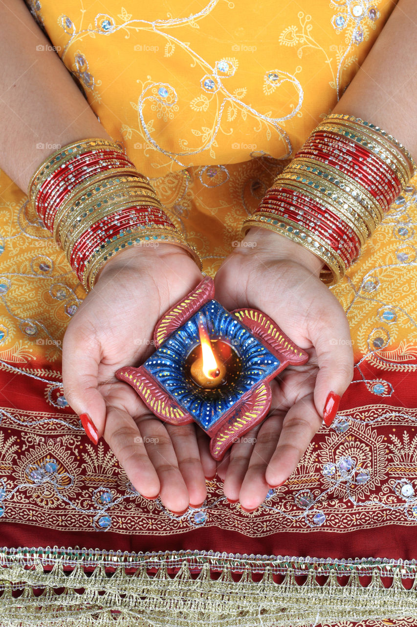 Indian festival Diwali diya on female hands