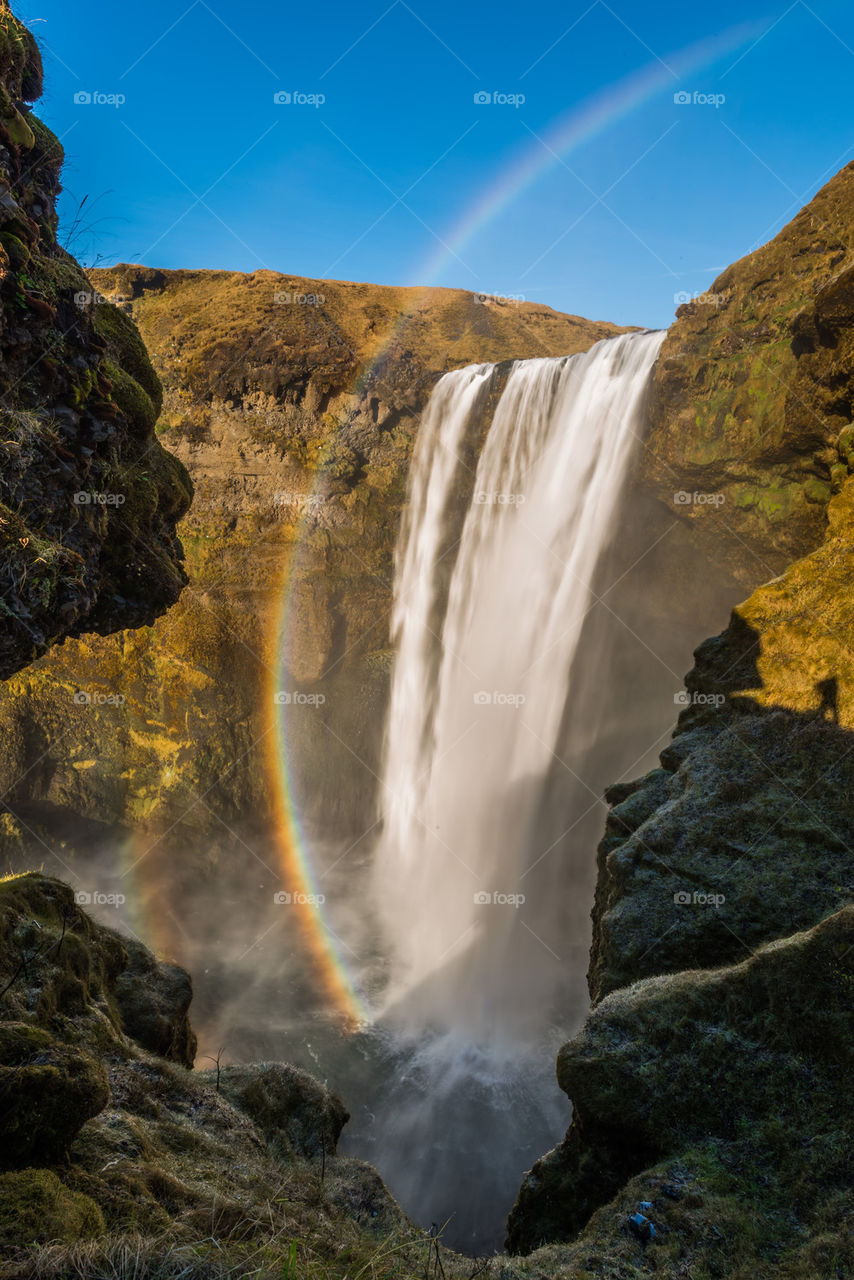 View of waterfall with rainbow