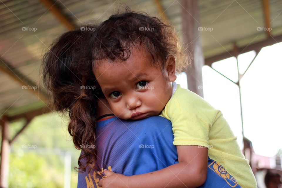 Timorese child being carried by his loving sister 