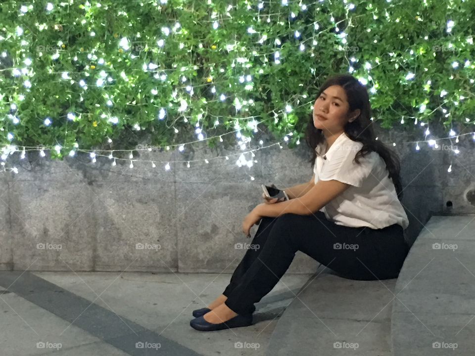Girl in the light park in front of Intercontinental hotel at the center of Bangkok Thailand 