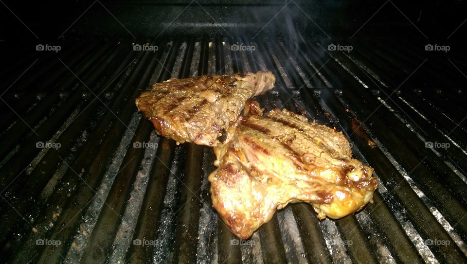Chicken on a grill. This is a photograph of some chicken grilling on a grill in the summer.