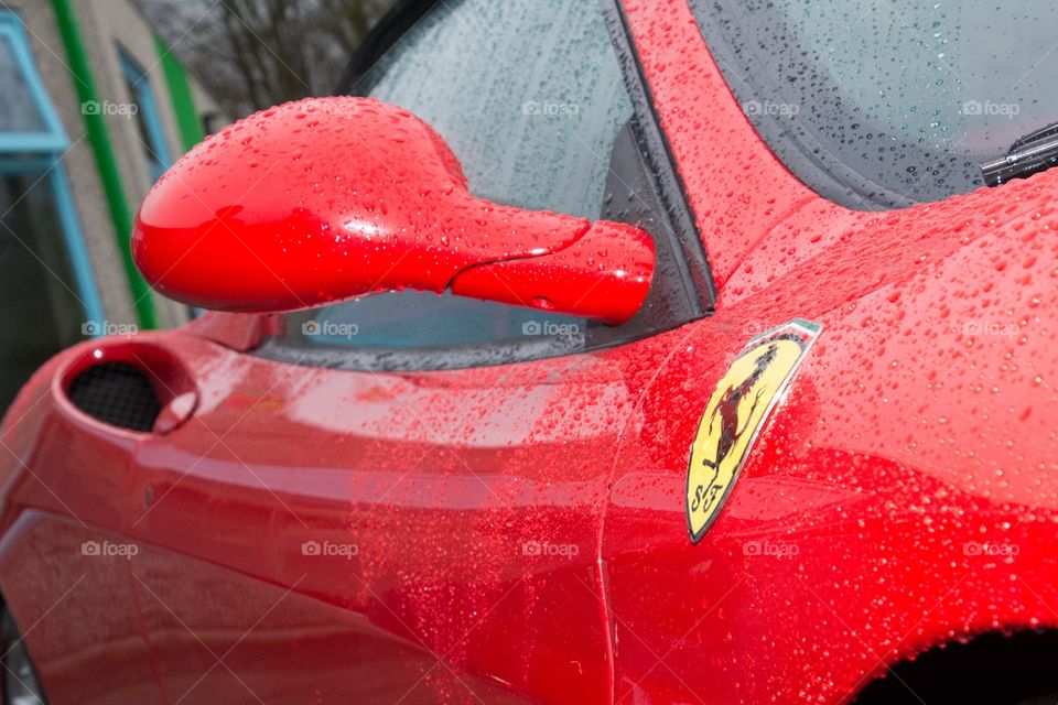 A red Ferrari  overs in rain drops