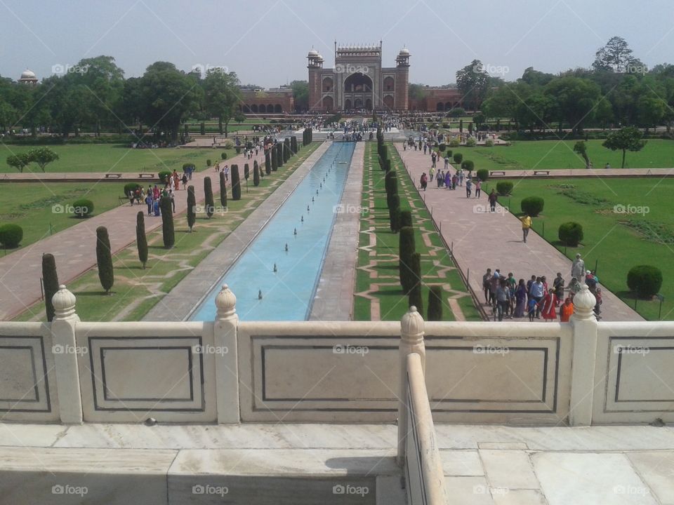 The Taj Mahal (/ˌtɑːdʒ məˈhɑːl, ˌtɑːʒ-/;[3] meaning Crown of the Palace[4]) is an ivory-white marble mausoleum on the south bank of the Yamuna river in the Indian city of Agra. It was commissioned in 1632 by the Mughal emperor, Shah Jahan (reigned from 1628 to 1658), to house the tomb of his favourite wife, Mumtaz Mahal. The tomb is the centrepiece of a 17-hectare (42-acre)[5] complex, which includes a mosque and a guest house, and is set in formal gardens bounded on three sides by a crenellated wall.