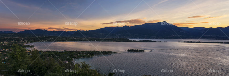 Panoramic view at sunrise on the lake Garda from the top of the ruins of the "Rocca di Manerba", Italy.