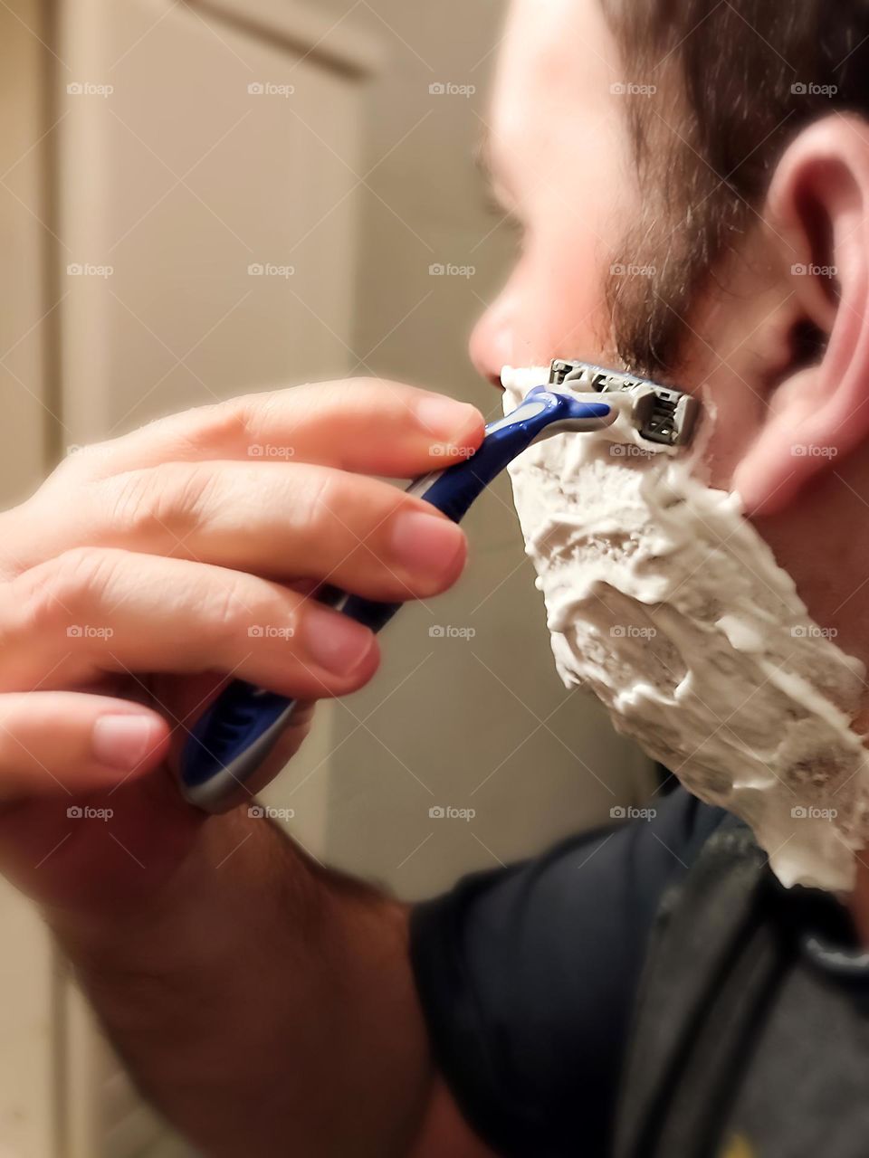 Man shaves his foamed beard