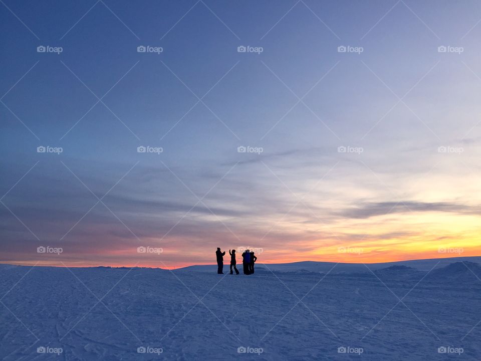 Tiny people seen from the distance at sunset in winter