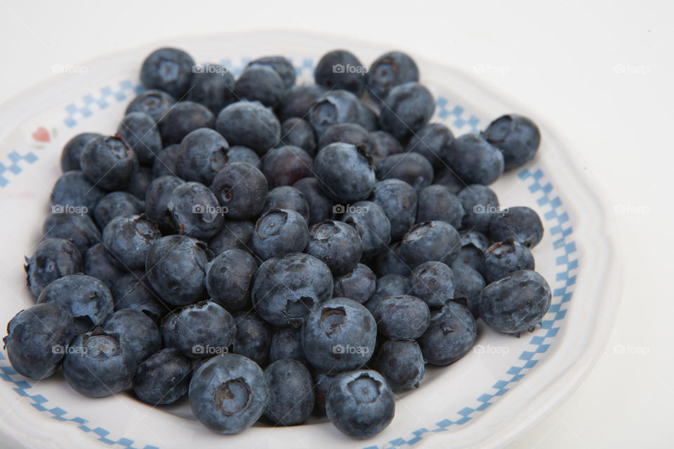 Fresh blueberries in a white bowl isolated on white shot in studio