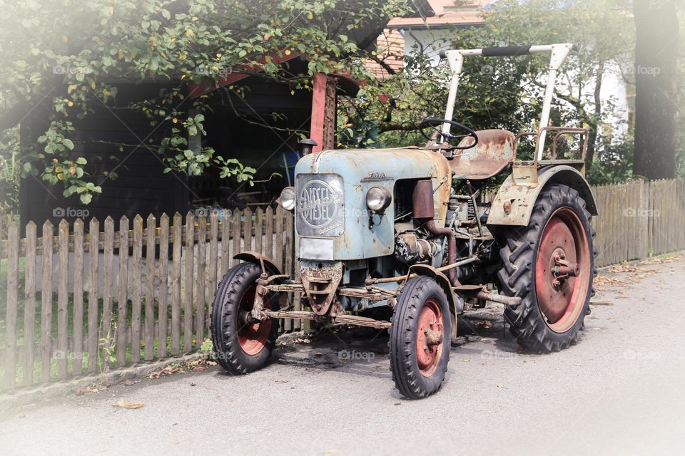 Old tractor in vintage mood parked on the street 