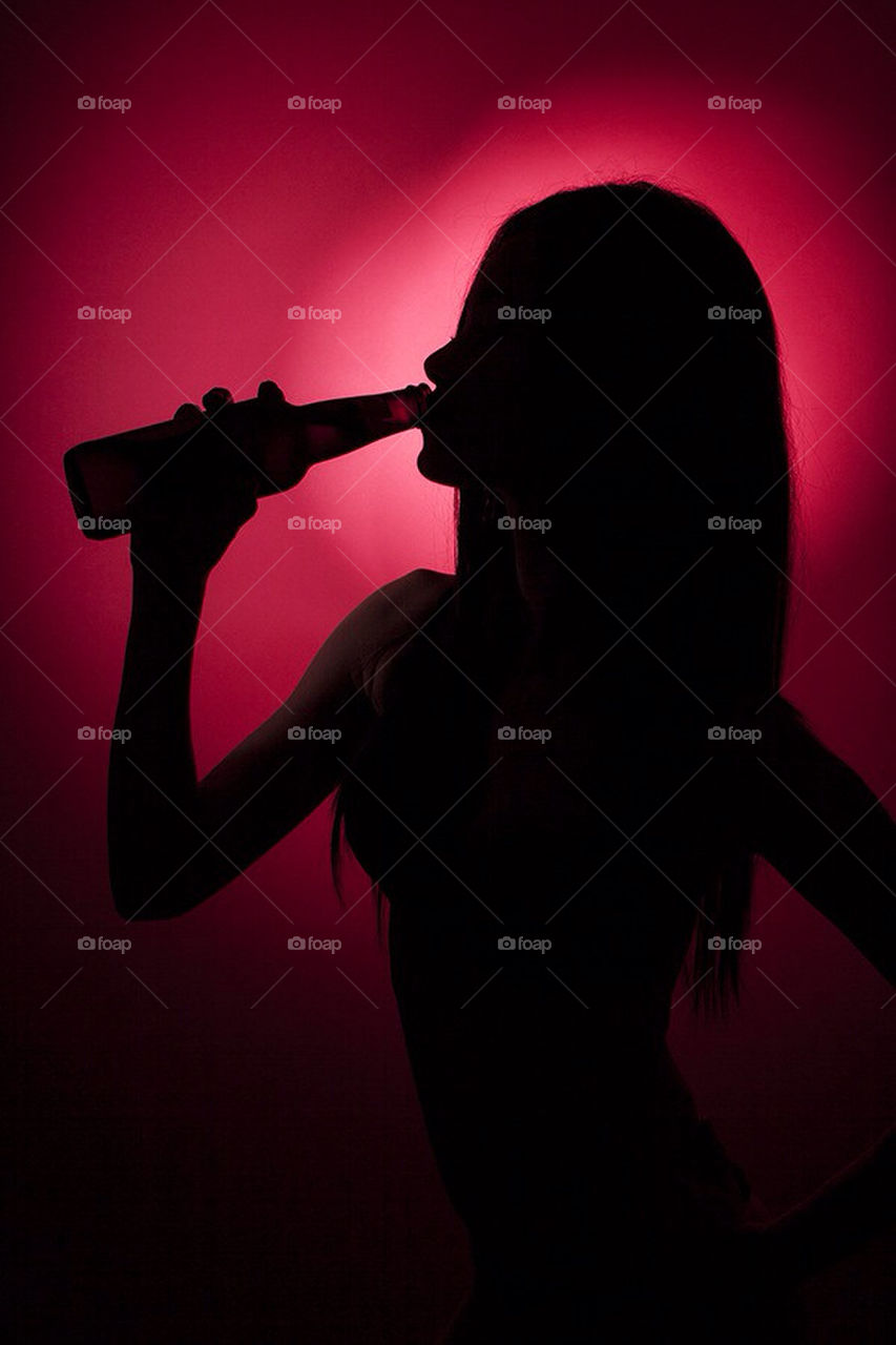 Silhouette. Silhouette of a young girl drinking beer