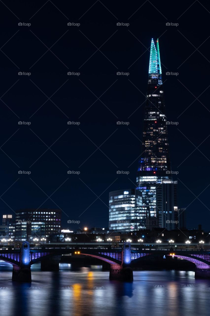 Skyscraper in the long exposure night behind the bridge