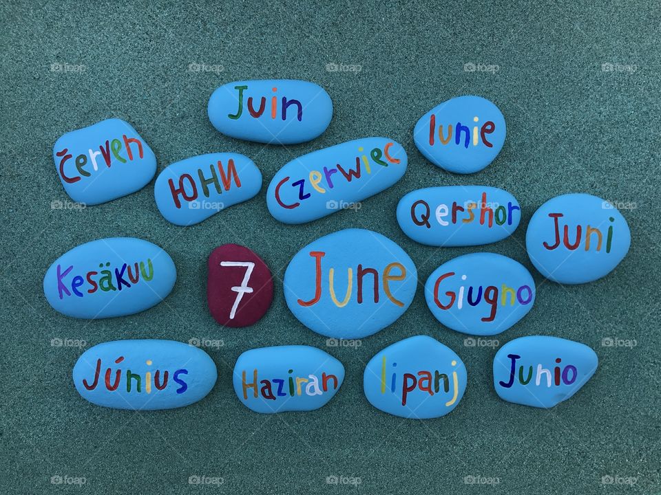 7 June, calendar date with colored stones over green sand